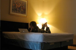 Foto de uma mulher deitada usando o Wi-fi de seu computador